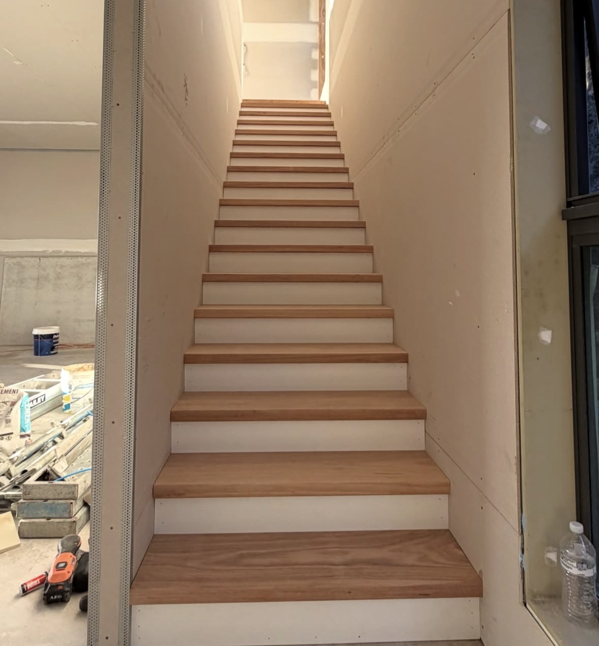 Timber treads and pale risers fitted into an interior stairwell